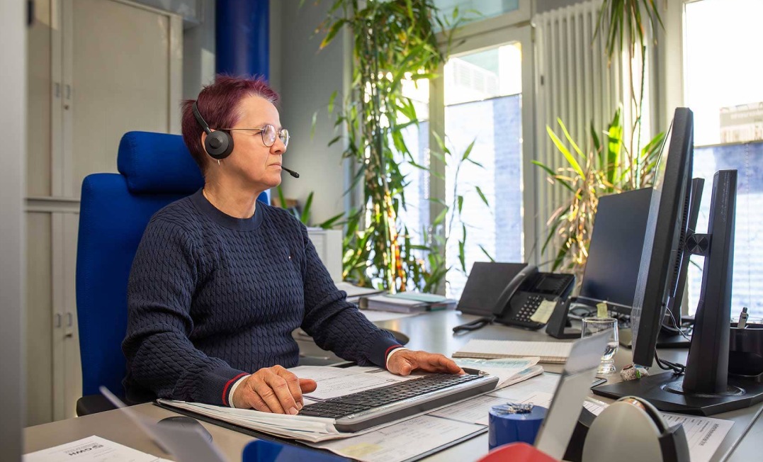 GWH-Mitarbeiterin vor Computer mit Headset